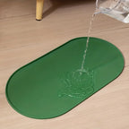 Água sendo despejada sobre um tapete oval verde com bordas elevadas.