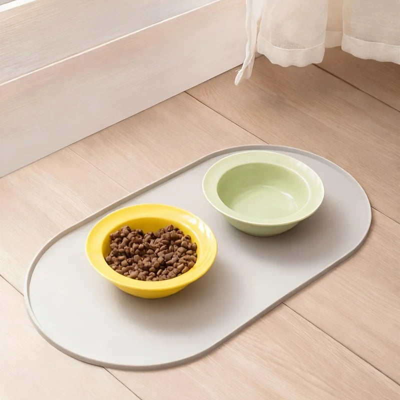 Duas tigelas sobre um tapete oval cinza-claro no piso de madeira. Tigelas e alimento não incluídos.