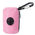 Um porta-sacos rosa-claro de tela com presilha preta e abertura para retirada.